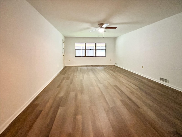 empty room with dark wood-type flooring and ceiling fan