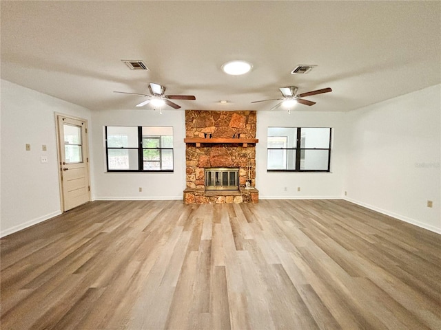 unfurnished living room with hardwood / wood-style floors, ceiling fan, a fireplace, and a textured ceiling