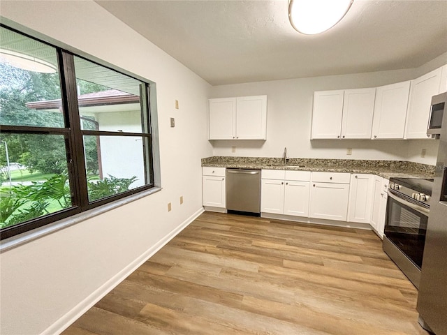 kitchen featuring light wood-type flooring, white cabinets, appliances with stainless steel finishes, and sink