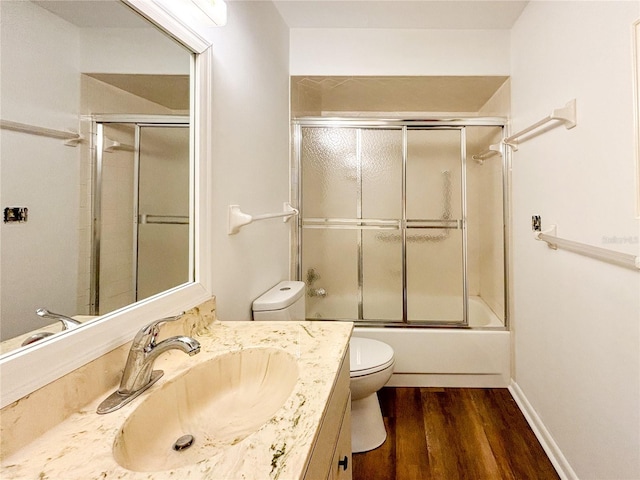 full bathroom with vanity, toilet, bath / shower combo with glass door, and wood-type flooring