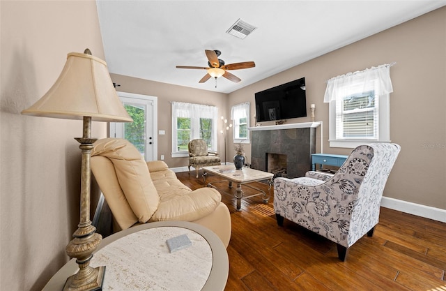 living room with a fireplace, dark hardwood / wood-style flooring, and ceiling fan