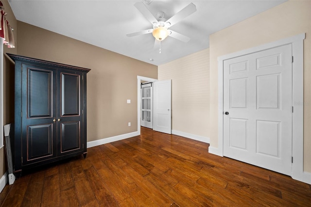 unfurnished bedroom with ceiling fan, a closet, and dark wood-type flooring