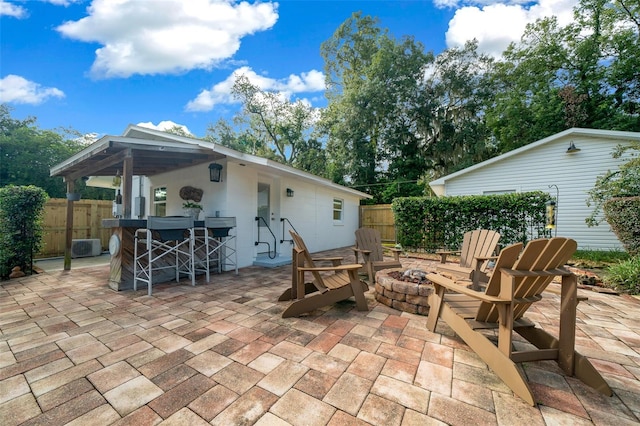 view of patio with exterior bar and a fire pit