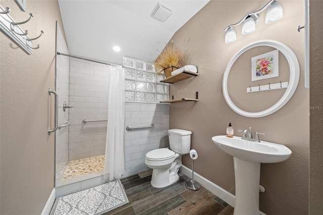 bathroom with vaulted ceiling, hardwood / wood-style flooring, toilet, and a shower with shower curtain