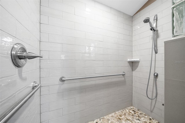 bathroom with vaulted ceiling and a tile shower