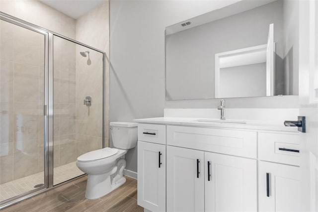 bathroom with vanity, toilet, and a shower with shower door