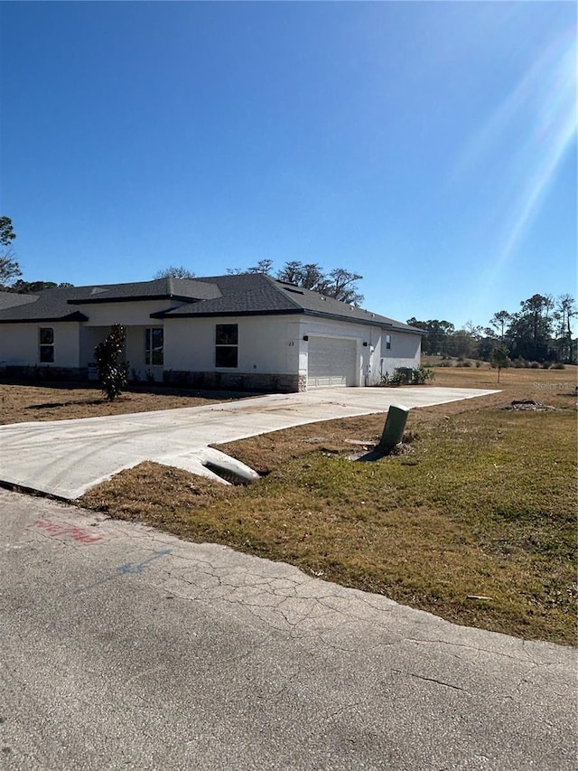 view of front of home with a garage and a front lawn