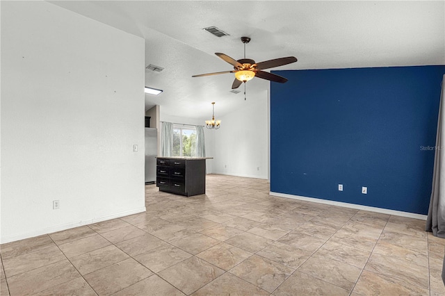 empty room featuring ceiling fan with notable chandelier, lofted ceiling, and a textured ceiling