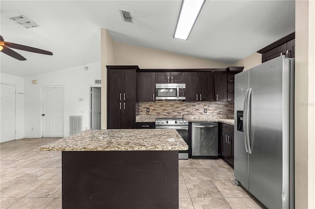 kitchen featuring appliances with stainless steel finishes, lofted ceiling, a center island, and ceiling fan