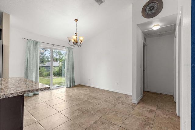 unfurnished dining area with a chandelier and a textured ceiling