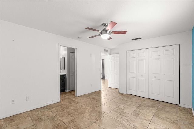 unfurnished bedroom featuring ceiling fan and a closet