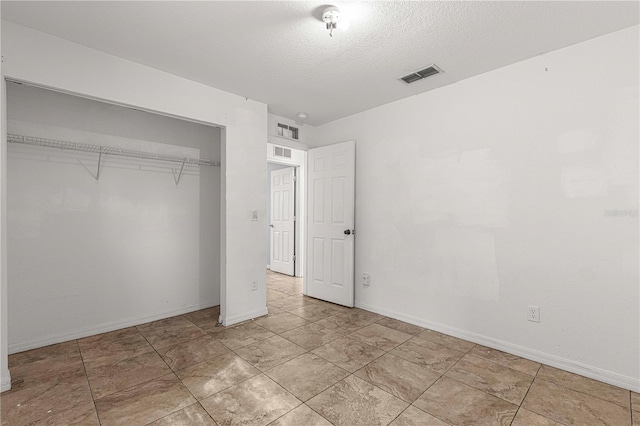 unfurnished bedroom with a textured ceiling and a closet