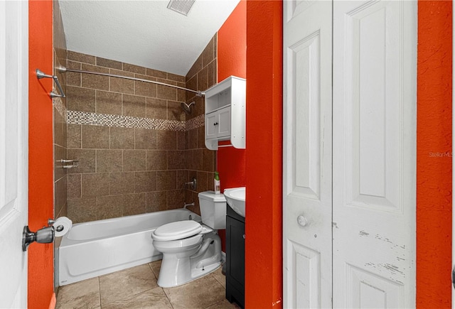 full bathroom featuring a textured ceiling, vanity, tile patterned flooring, toilet, and tiled shower / bath combo