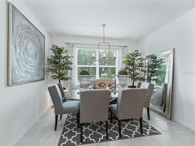 dining area with light tile patterned floors, a textured ceiling, and an inviting chandelier