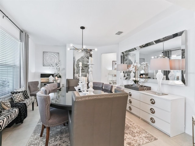 dining room with a chandelier, a healthy amount of sunlight, and light tile patterned floors