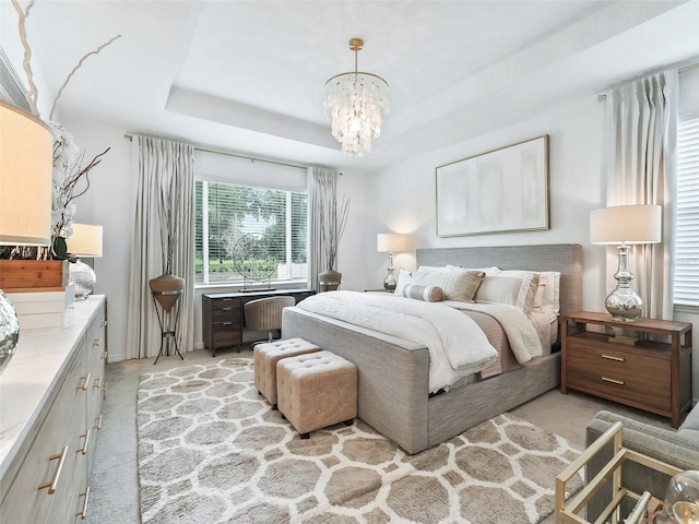 carpeted bedroom with a raised ceiling and a chandelier