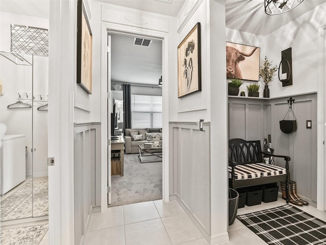 hall with washer and dryer and light tile patterned floors