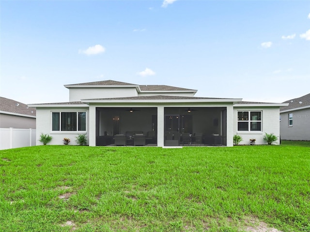 back of house featuring a lawn and a sunroom