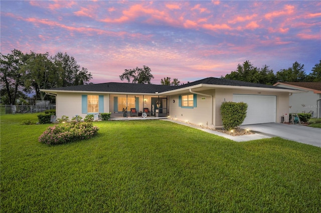 ranch-style house featuring a lawn and a garage