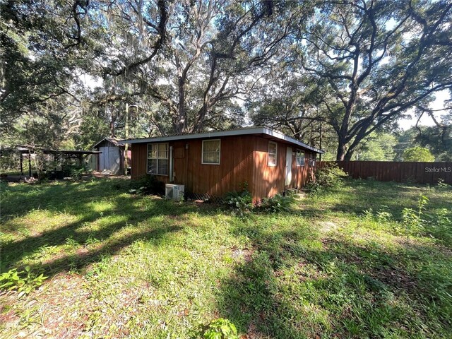 view of yard featuring ac unit and a storage unit