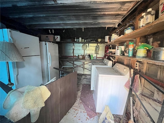 kitchen featuring washing machine and dryer, concrete flooring, and white fridge