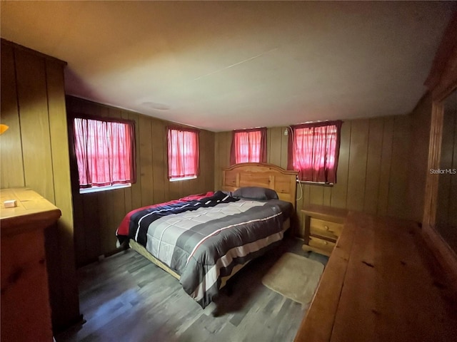 bedroom featuring hardwood / wood-style floors and wooden walls