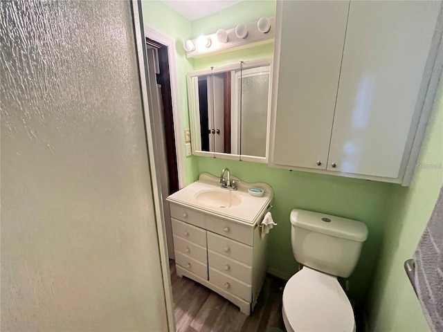 bathroom with vanity, toilet, and wood-type flooring