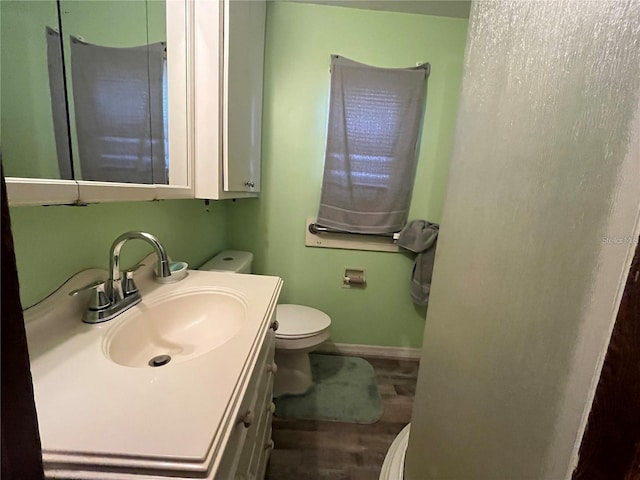 bathroom featuring vanity, toilet, and wood-type flooring