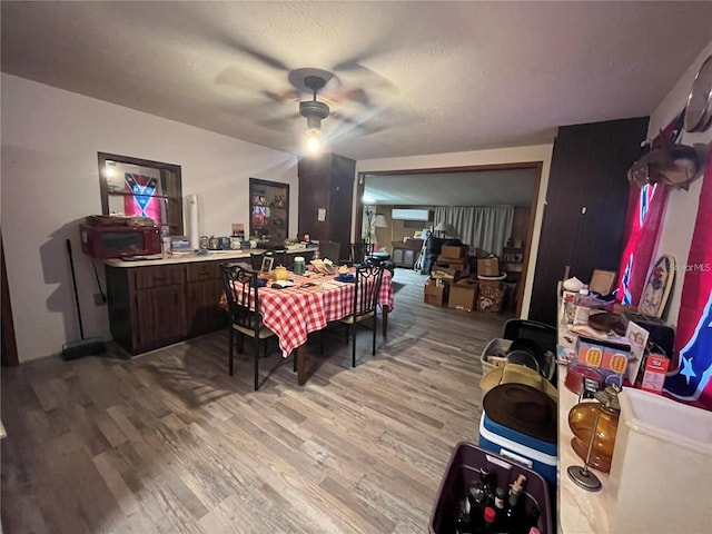 dining room featuring hardwood / wood-style floors, ceiling fan, and a textured ceiling