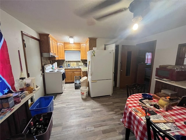 kitchen featuring light wood-type flooring, white appliances, sink, ceiling fan, and decorative backsplash