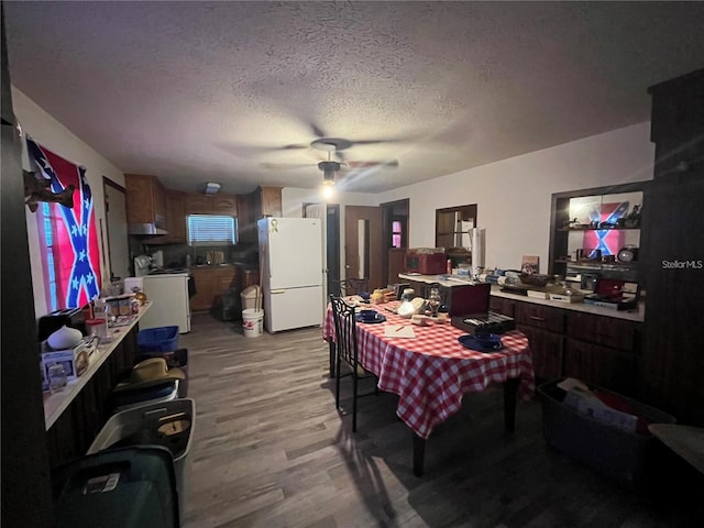 interior space featuring a textured ceiling, light hardwood / wood-style flooring, ceiling fan, and white fridge