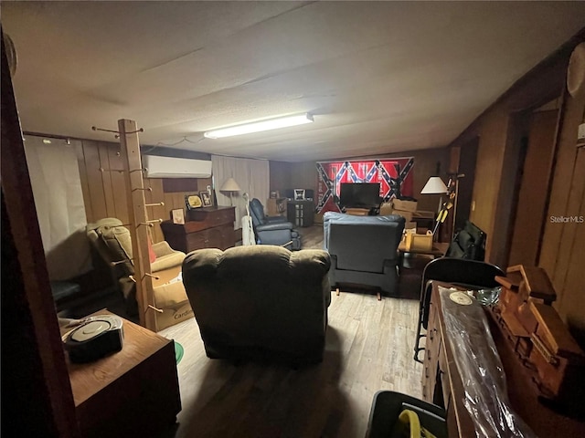 living room featuring a wall mounted AC and wood-type flooring