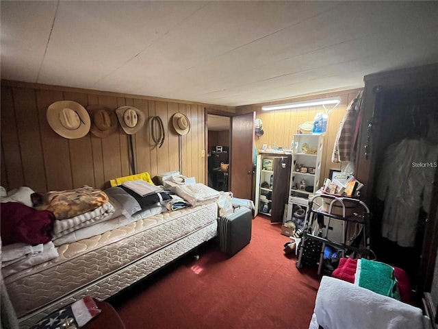 bedroom featuring wood walls and carpet floors