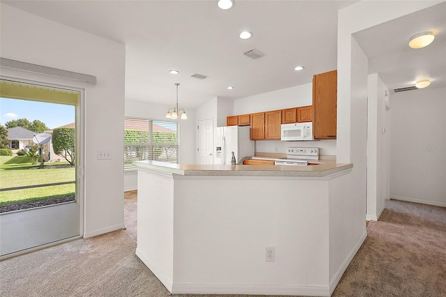 kitchen with light carpet, white appliances, kitchen peninsula, an inviting chandelier, and hanging light fixtures