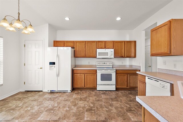 kitchen with white appliances, pendant lighting, and a chandelier