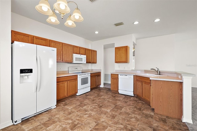 kitchen with white appliances, a notable chandelier, hanging light fixtures, kitchen peninsula, and sink