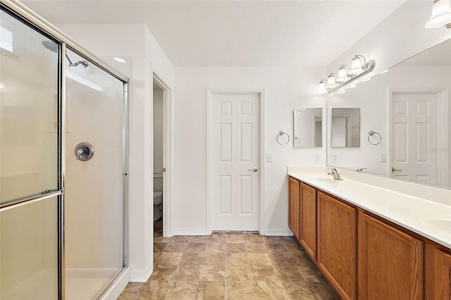 bathroom featuring walk in shower, toilet, and vanity