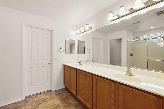 bathroom featuring a textured ceiling, vanity, and walk in shower