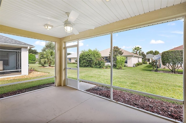 unfurnished sunroom with ceiling fan