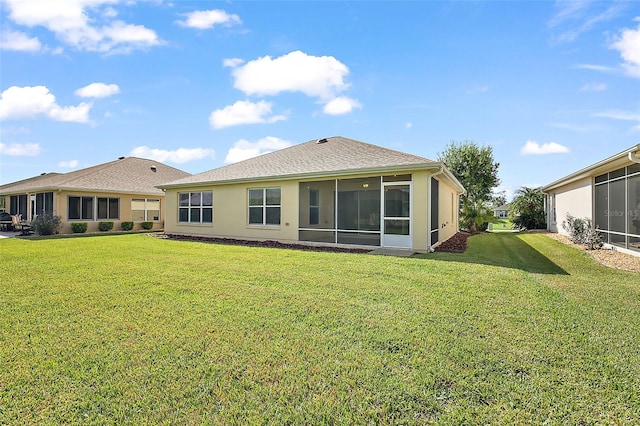 back of property with a sunroom and a yard