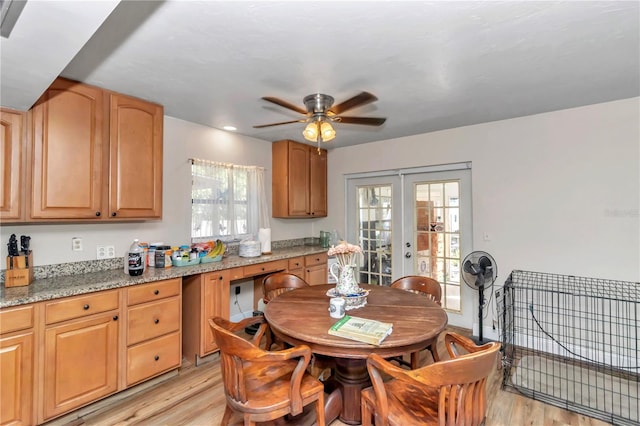 kitchen with light hardwood / wood-style floors, light stone countertops, ceiling fan, and french doors