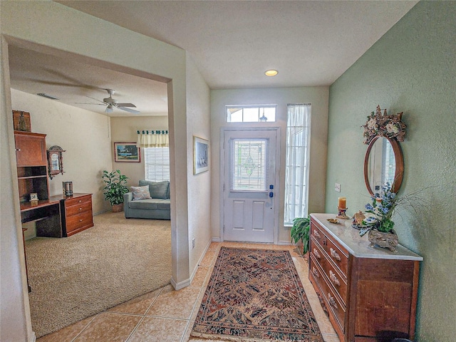 carpeted foyer with a textured ceiling and ceiling fan