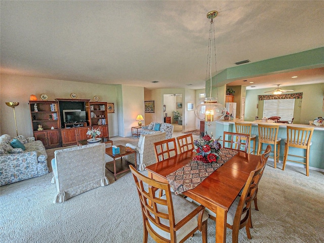 dining area featuring a textured ceiling, ceiling fan, and carpet flooring