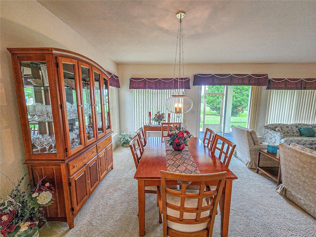 carpeted dining room with an inviting chandelier and a textured ceiling