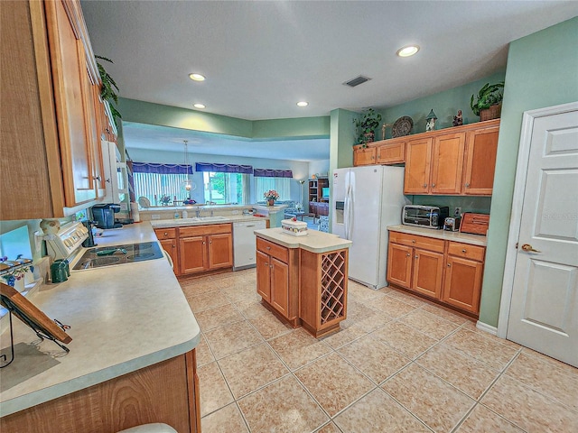 kitchen with white refrigerator with ice dispenser, a kitchen island, stainless steel dishwasher, kitchen peninsula, and light tile patterned flooring