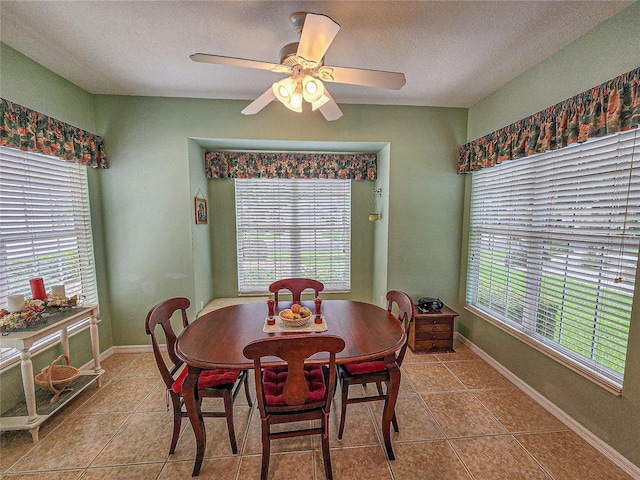 tiled dining area with ceiling fan, a wealth of natural light, and a textured ceiling