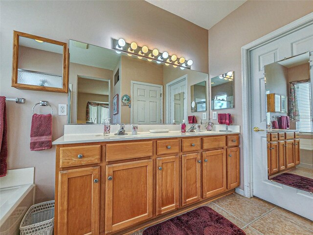 bathroom with vanity, a bath, and tile patterned floors