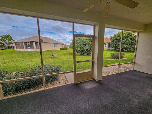 unfurnished sunroom featuring ceiling fan