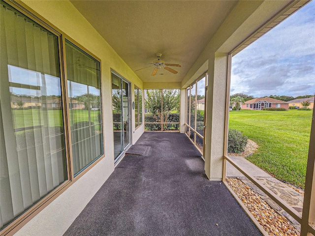 unfurnished sunroom with ceiling fan