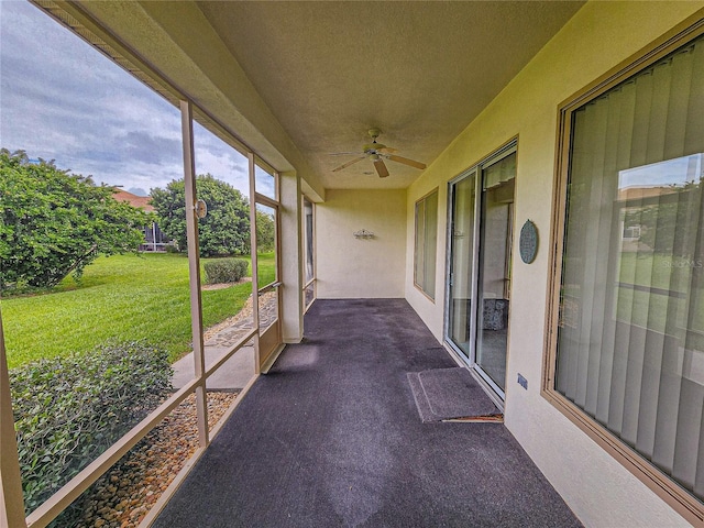 unfurnished sunroom with ceiling fan